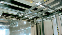 Overhead monorail system in a paint finishing system with shifting bridge